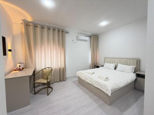 a bedroom with a bed and a desk and a chair at CMC Hotel Apartment in Samarkand