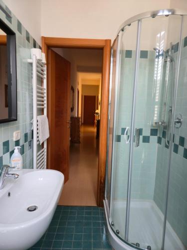 a bathroom with a sink and a glass shower at Alfredo II Affittacamere in Siena