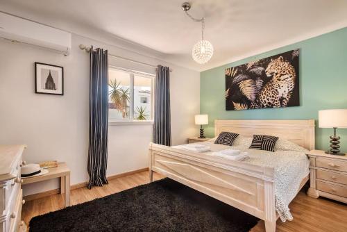 a bedroom with a bed and a painting on the wall at Apartamento Alquimia by Algarve Holidays in Vale do Lobo