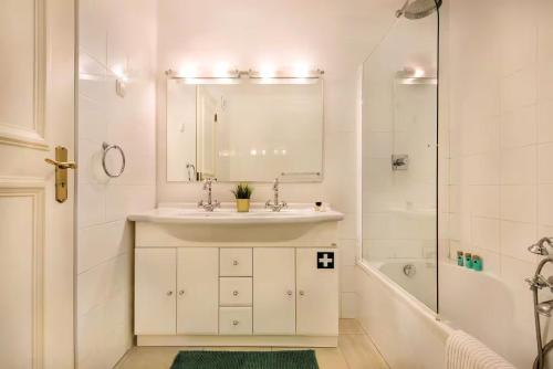 a white bathroom with a sink and a mirror at Apartamento Alquimia by Algarve Holidays in Vale do Lobo
