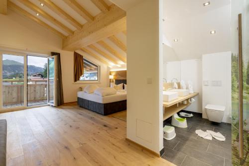 a bedroom with a bed and a sink and a bathroom at Familotel Kaiserhof - Families only in Berwang
