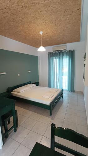 a large bed in a room with a ceiling at Ferouli Residence in Rizá