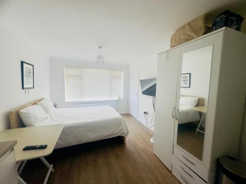 a small bedroom with a bed and a desk at Studio - Sleeps 2 - Wifi - Parking in Dunstable