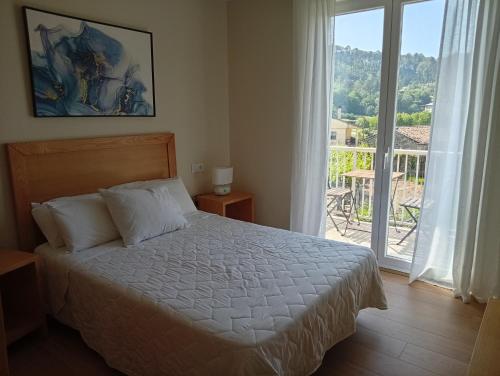 a bedroom with a bed and a large window at Casa Da Ponte in Lobios