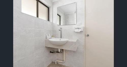a white bathroom with a sink and a mirror at A&A Lodge Motel in Emerald