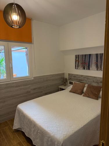 a bedroom with a white bed and a window at Casa de Joaquina in O Grove