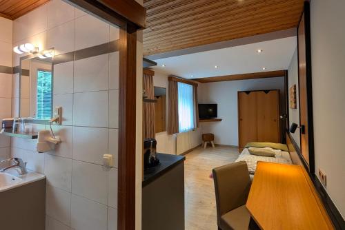 a small room with a sink and a bedroom at Hotel Apartment Das Au- Gut in Hallein