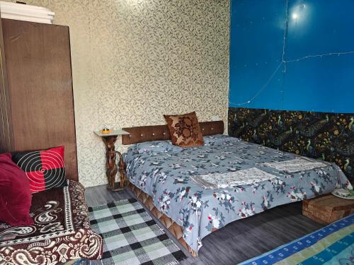 a bedroom with a bed and a blue wall at Theprefabnest in Rishīkesh
