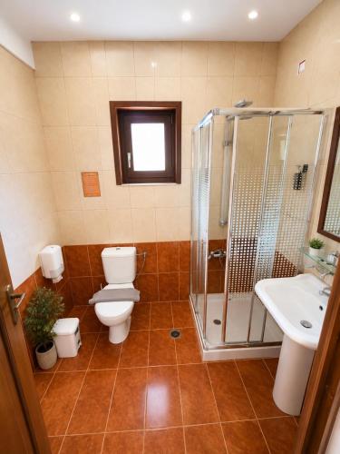 a bathroom with a toilet and a shower and a sink at Aristotelis in Ancient Epidauros