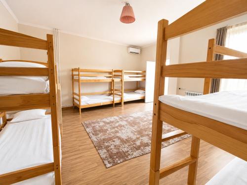 a room with three bunk beds and a rug at Dreamers Hostel & Hotel Apartment in Yerevan