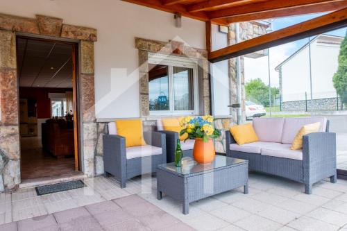 a patio with two couches and a table at El Jardin de Pruvia in Llanera