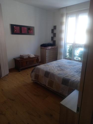 a bedroom with a bed and a large window at Casa Floris in Imola