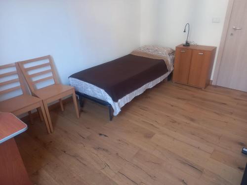 a small bedroom with a bed and two chairs at Casa Floris in Imola