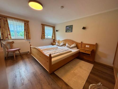 a bedroom with a bed and a chair in it at Bergbauernhof Haug in Bad Hindelang