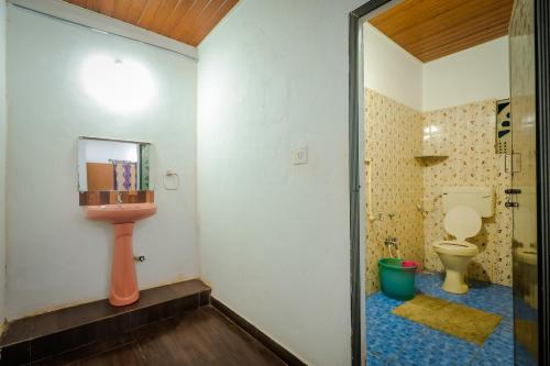 a bathroom with a toilet and a sink at The Breeze Cottage in Kalasa