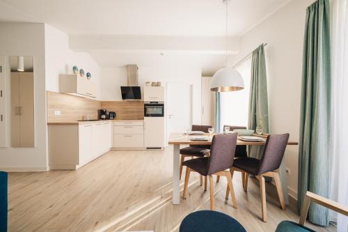 a kitchen and dining room with a table and chairs at Am Park 26 in Prerow