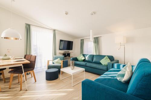 a living room with a blue couch and a table at Am Park 26 in Prerow