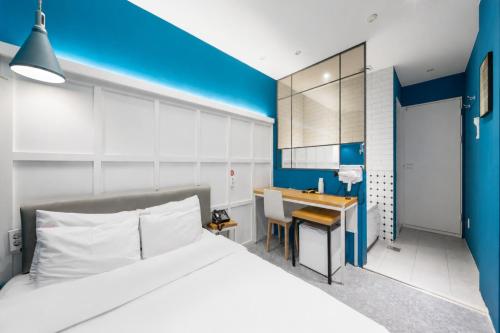 a bedroom with a bed and a desk in it at NU Hotel in Cheonan