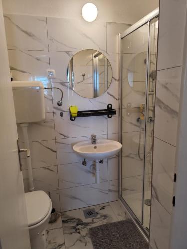 a bathroom with a toilet and a sink and a mirror at Apartments Boćin Rosso in Hvar