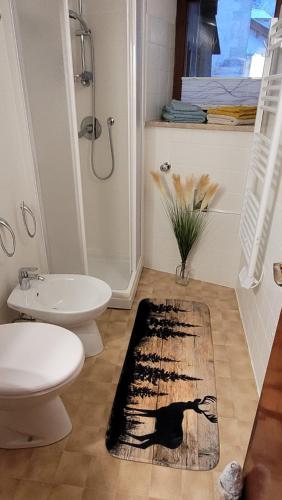 a bathroom with a black cat rug on the floor at Maison Cavalese - Polar Express in Cavalese