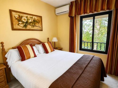 a bedroom with a large bed and a window at Macdonald La Ermita Resort in Mijas