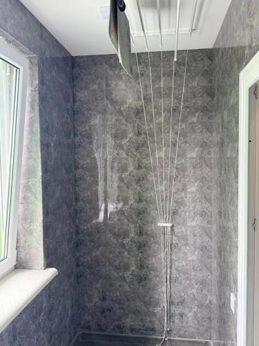 a shower in a bathroom with a black wall at Дім Гаваї in Chechelivka