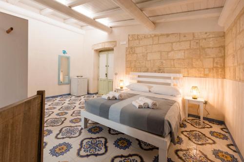 a bedroom with a bed with two towels on it at Tenuta Monsalvato in Otranto