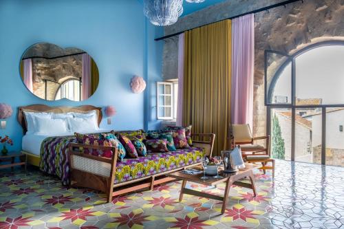 a hotel room with a bed and a couch at L'Arlatan in Arles