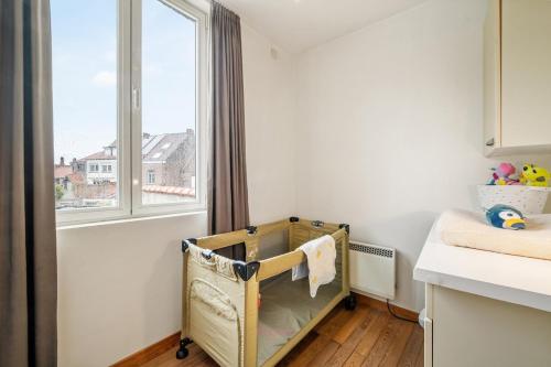a baby crib in a room with a window at Parkhuisje by BLOSS in Bruges