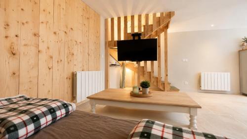a living room with a table and a tv at Maison 8 personnes avec terrasse in Verdun