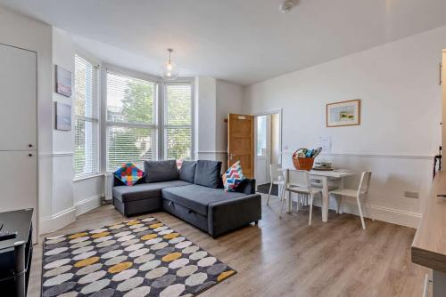 a living room with a couch and a table at Dizzy Lows Modern 1 Bedroom Swanage Apartment with Sea View in Swanage