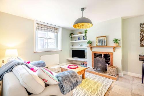 a living room with a couch and a fireplace at Passiflora Cottage Close to Swanage Beach and Town Sleeps 7 in Swanage