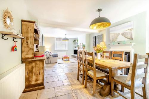 a kitchen and dining room with a wooden table and chairs at Passiflora Cottage Close to Swanage Beach and Town Sleeps 7 in Swanage