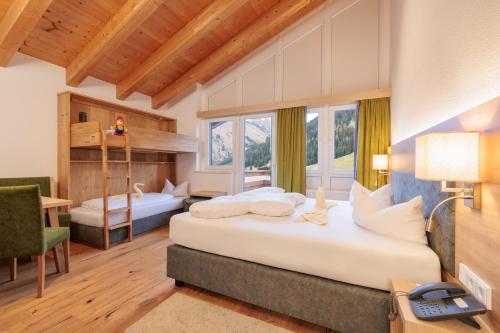 a hotel room with two beds and a desk at Familotel Kaiserhof - Families only in Berwang