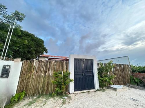 a wooden fence with a black door in a yard at Casa Rio - Santo Amaro in Santo Amaro