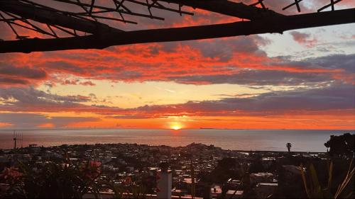 a sunset over a city with the ocean at Casa Enza in Forio d'Ischia