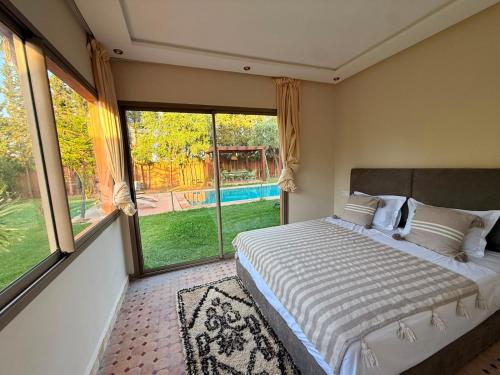 a bedroom with a bed and a large window at Villa avec Piscine Chauffée Privée pour Familles in Marrakesh