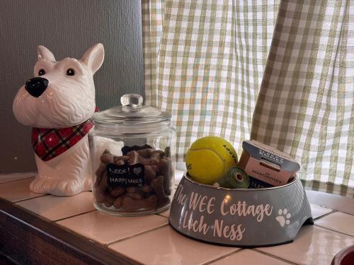 a jar of food and a cat toy on a counter at Loch Ness village cottage for 2 with free parking & pets welcome in Drumnadrochit