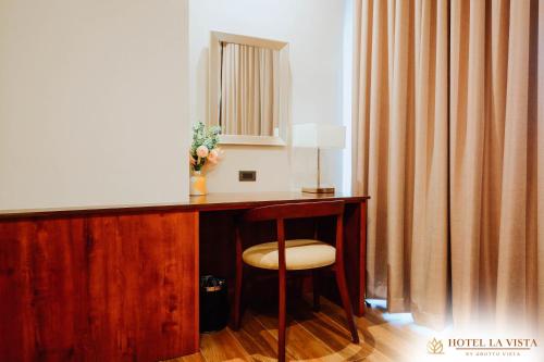 a room with a desk with a chair and a mirror at Hotel La Vista by Grotto Vista in Mangangpico