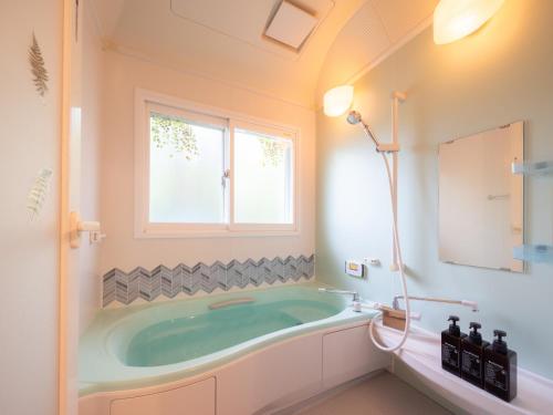 a bathroom with a tub and a window at みどりの風 -那須高原中心地-森を感じる貸切一軒家-観光や買い物に便利-無料bbq-最大7名-子供歓迎 in Nasu