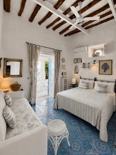 a bedroom with a bed and a couch and a table at Casa Prete in Panarea