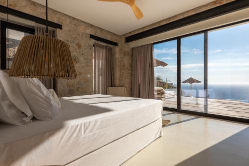 a bedroom with a bed with a view of the ocean at NeRó Villas Lefkada in Tsoukalades