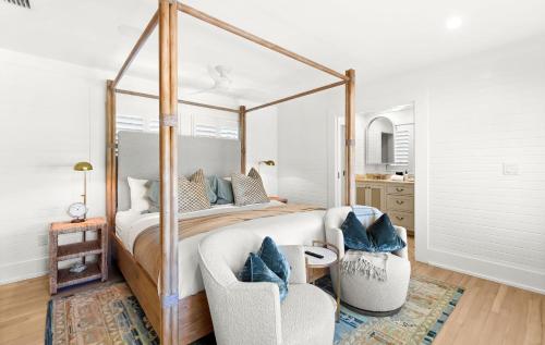 a bedroom with a canopy bed and two chairs at Luv U Honey in Santa Rosa Beach