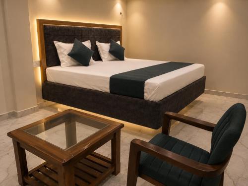 a bedroom with a bed and a chair and a table at Hotel Bhagirath Palace in Ahraurā Road