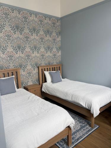 two beds in a room with a wall at The Old Bank in Warrenpoint