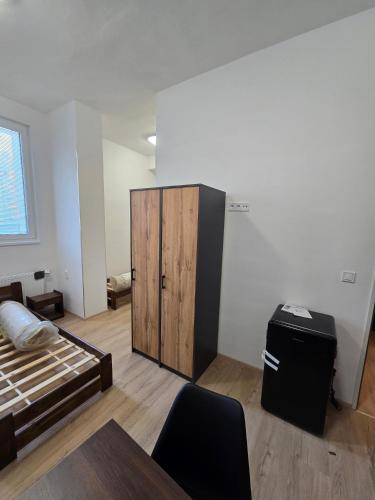 a room with a bed and a wooden cabinet at Ubytovna Chropyně in Kroměříž