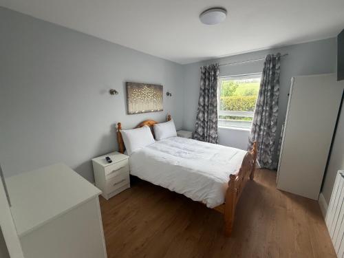 a small bedroom with a bed and a window at Doherty,s Chalet in Doon