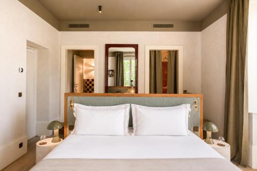a bedroom with a large white bed with two pillows at ROSEMARY hôtel in Bastia