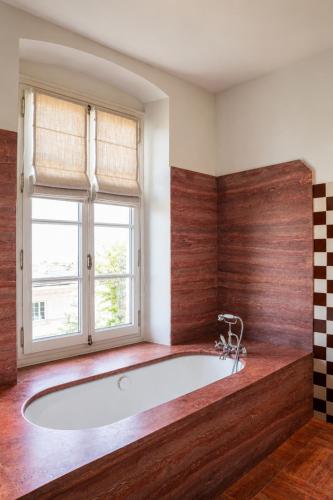 a large bath tub in a room with a window at ROSEMARY hôtel in Bastia