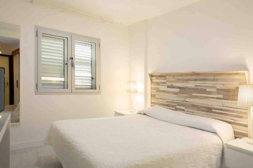 a white bedroom with a bed and a window at Numancia 1-1A in Las Palmas de Gran Canaria